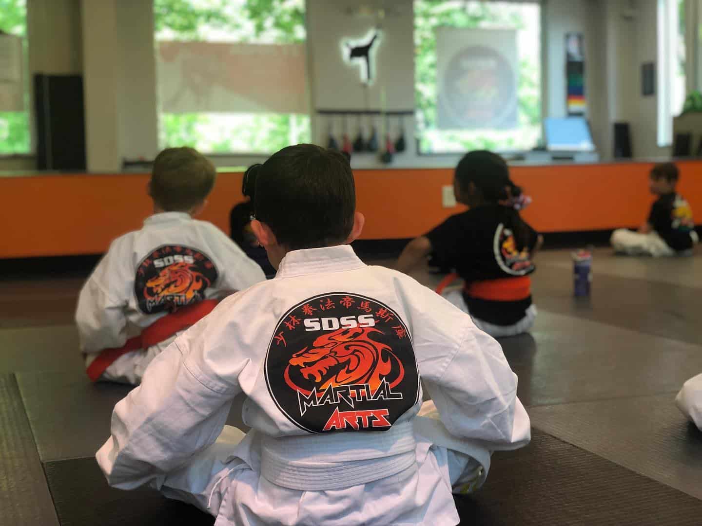 karate students sitting with legs crossed in front of them